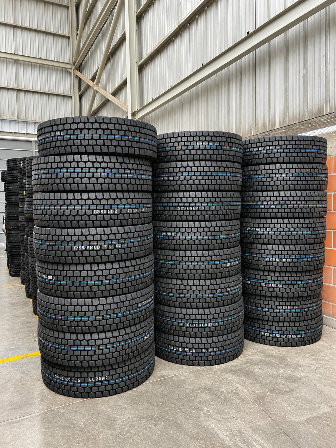 Inventario de llantas de camión apiladas en la bodega de Surllantas